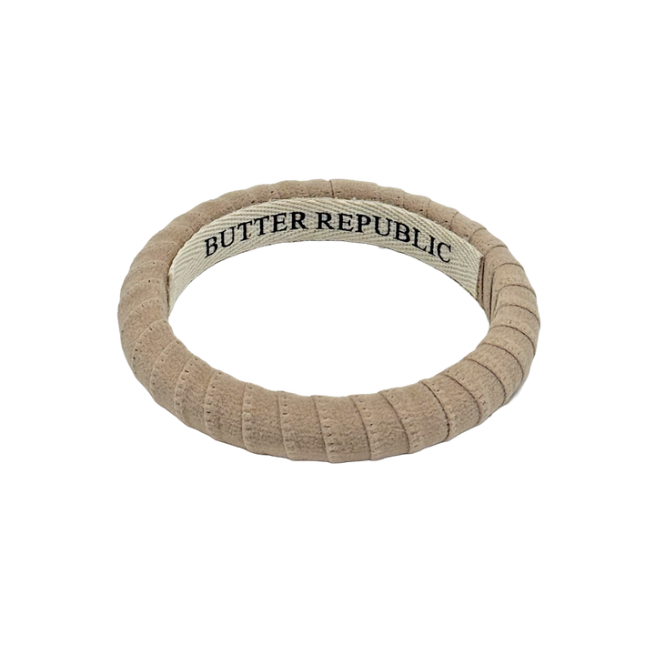 beige suede Butter Republic bracelet with logo brand label on the bracelet interior