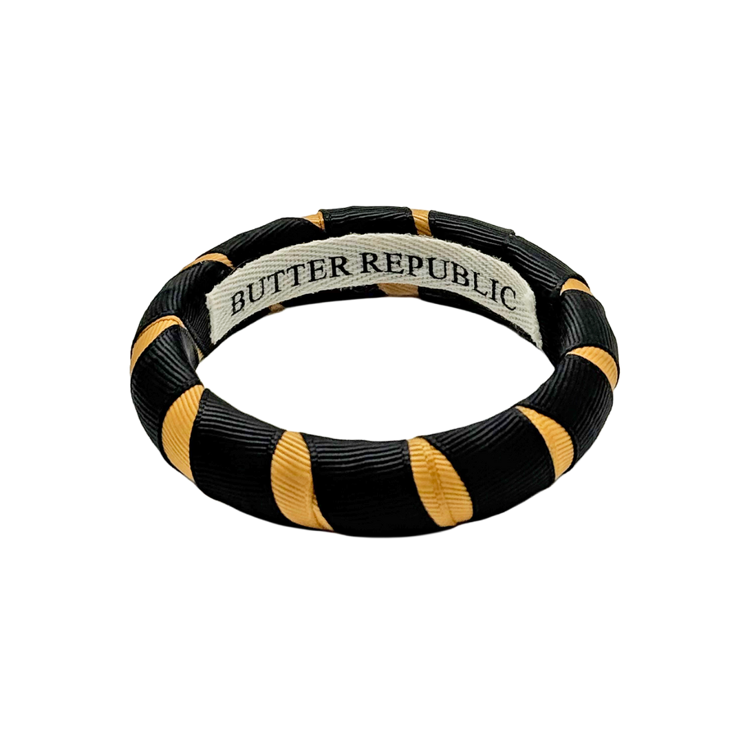 black and gold Butter Republic bracelet with logo brand label on the bracelet interior
