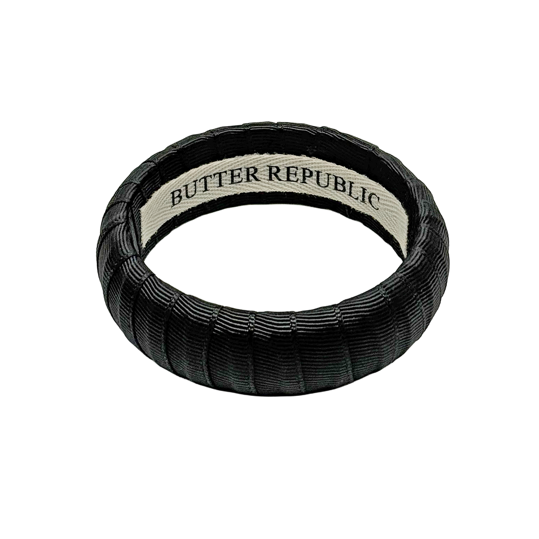 Black bracelet with Butter Republic brand label on the interior