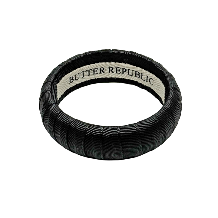 Black bracelet with Butter Republic brand label on the interior