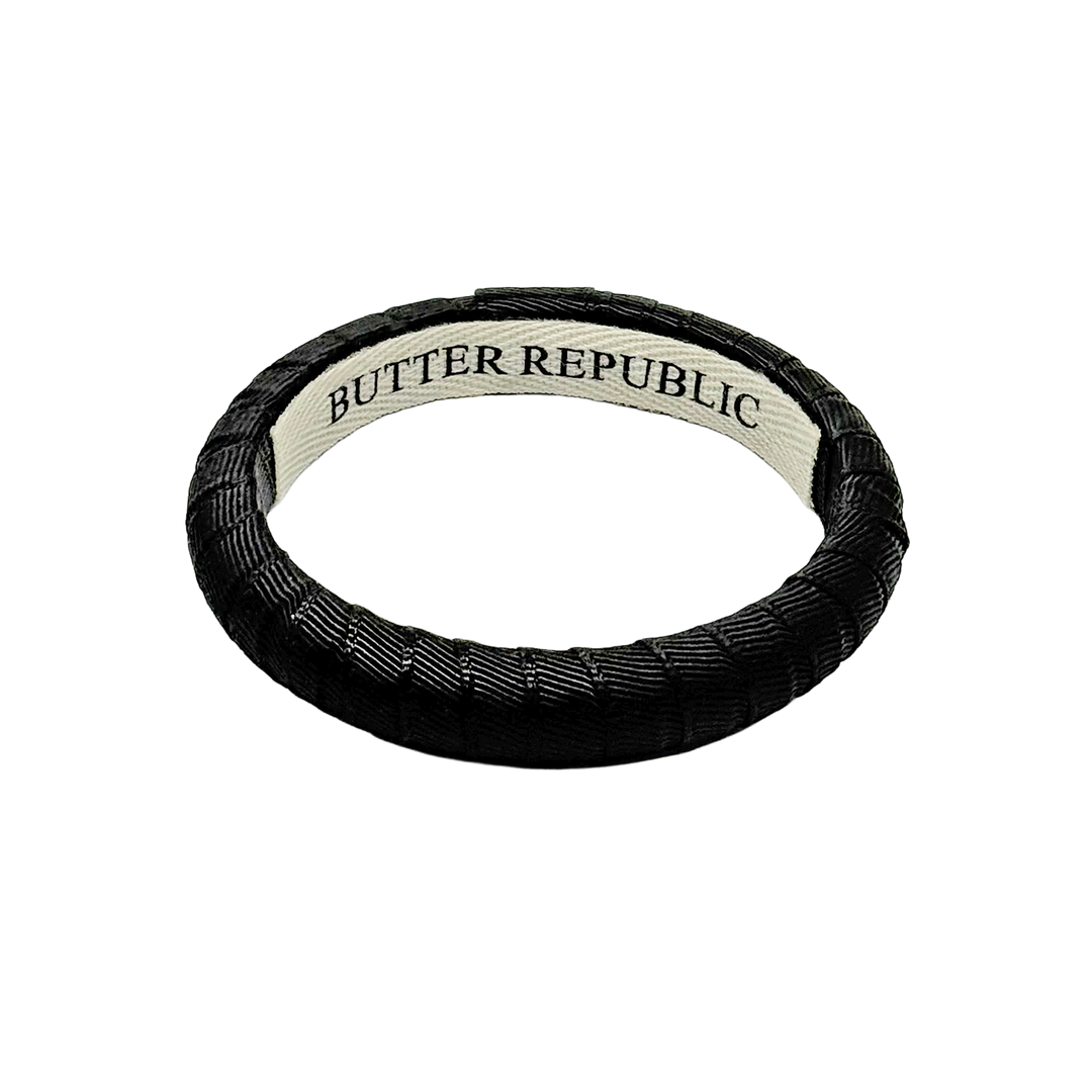 narrow black Butter Republic bracelet with brand label on the interior