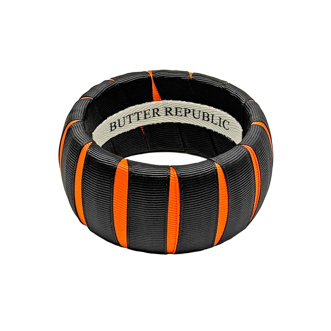 A black and orange Butter Republic bangle bracelet