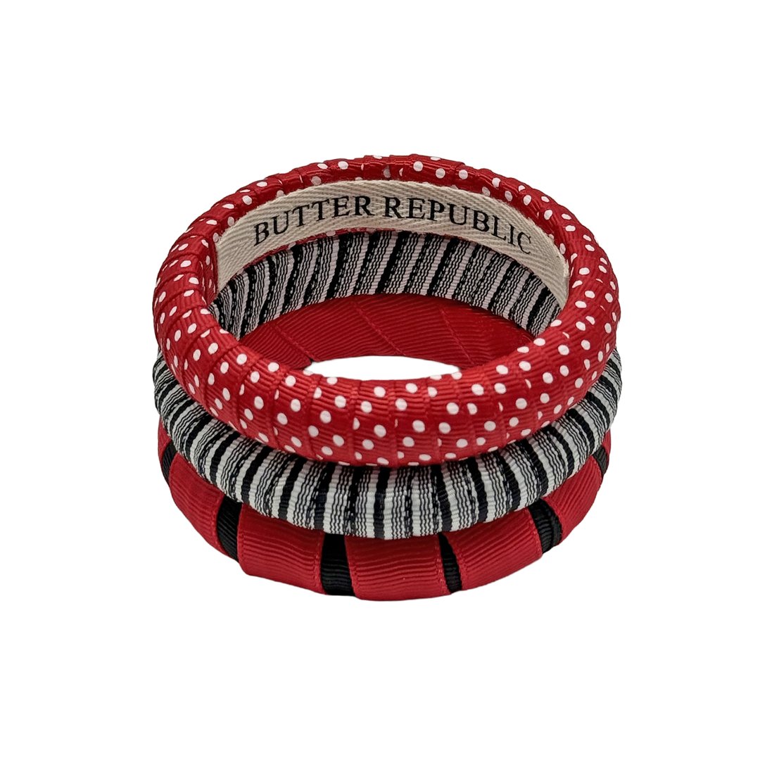 three black and red Butter Republic bracelets with logo brand label on the interior of the bracelets