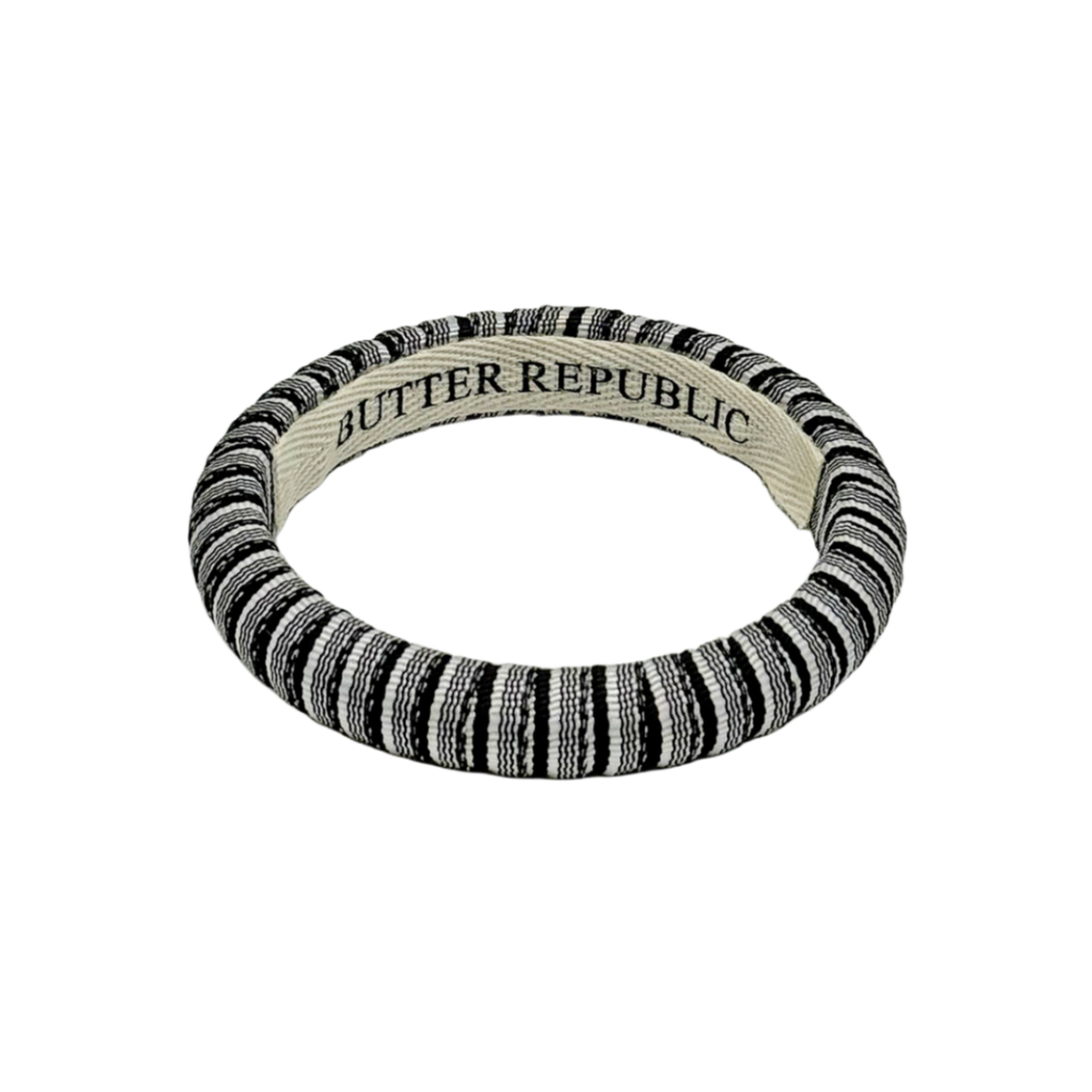 black and white pinstripe Butter Republic bracelet with logo brand label on the interior of the bracelet