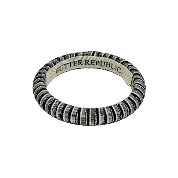 black and white pinstripe Butter Republic bracelet with logo brand label on the interior of the bracelet