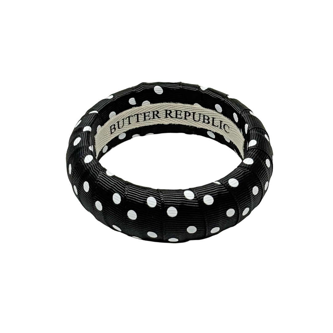 Black and white polka dot bracelet with Butter Republic brand label on the interior