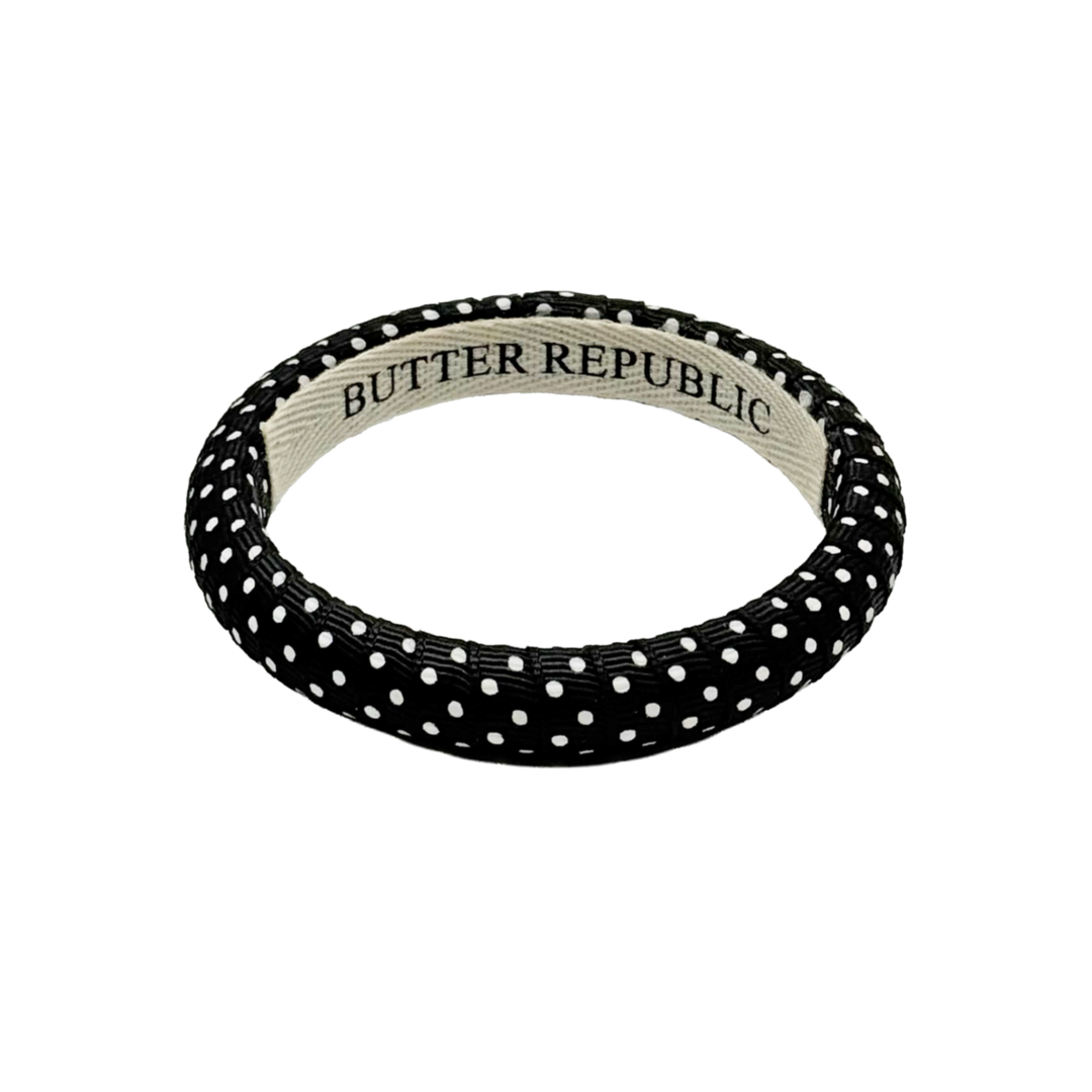black polka dot Butter Republic bracelet with logo brand label on the interior of the bracelet
