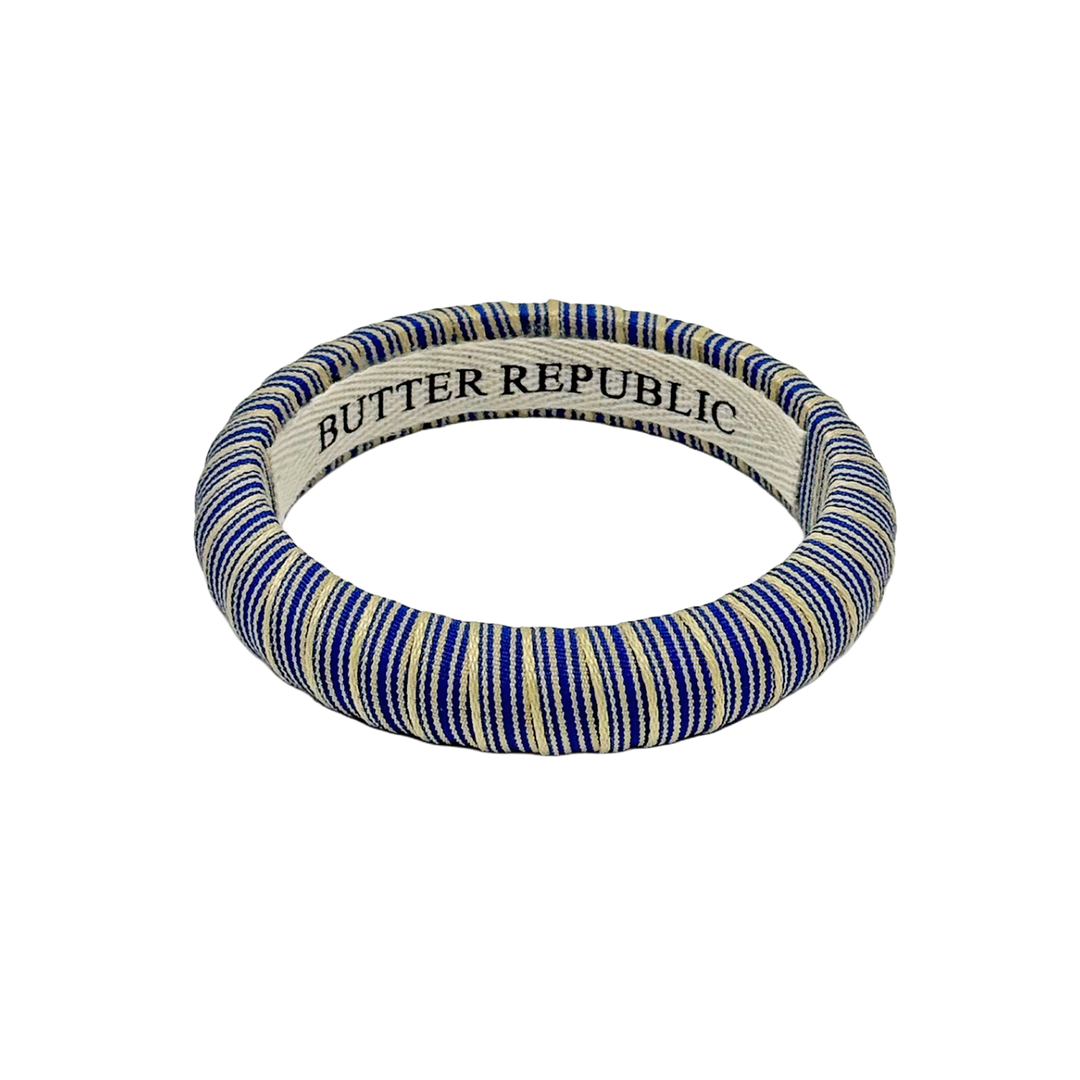 blue and cream striped Butter Republic bracelet with logo brand label on the interior of the bracelet