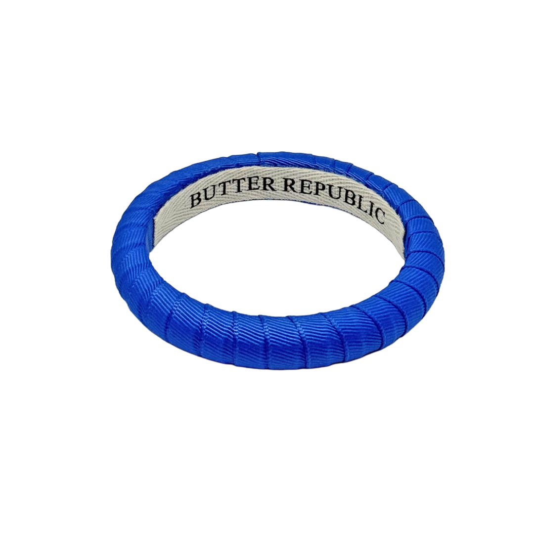 narrow blue Butter Republic bracelet with brand label on the interior