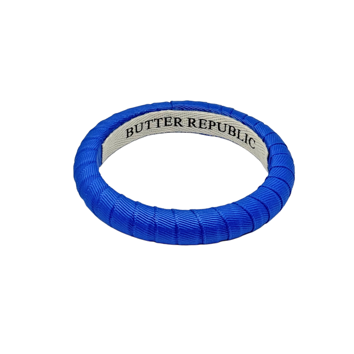narrow blue Butter Republic bracelet with brand label on the interior