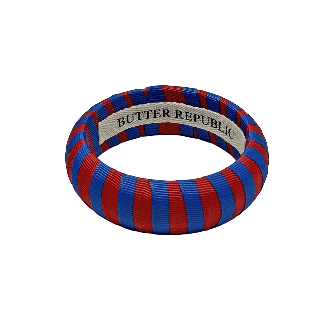 red and blue striped Butter Republic bracelet with logo brand label on the interior of the bracelet