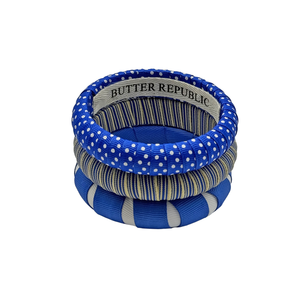 three blue and white Butter Republic bracelets with logo brand label on the interior of the bracelet
