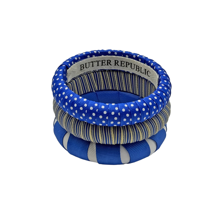three blue and white Butter Republic bracelets with logo brand label on the interior of the bracelet