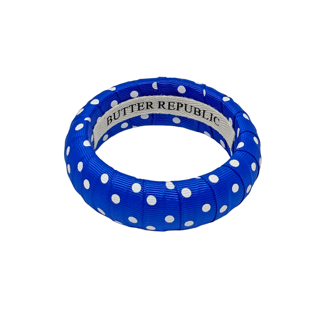 Blue and white polka dot bracelet with Butter Republic brand label on the interior