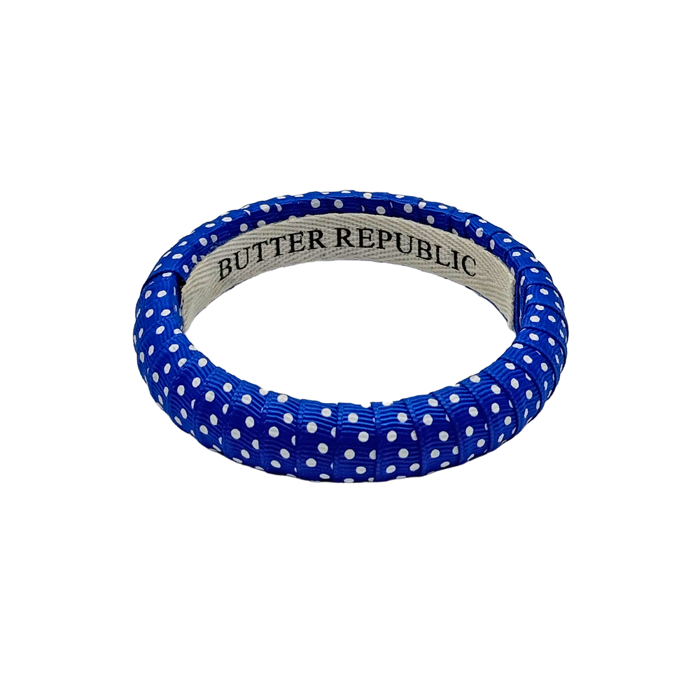 blue and white Swiss dot Butter Republic bracelet with logo brand label on the interior of the bracelet