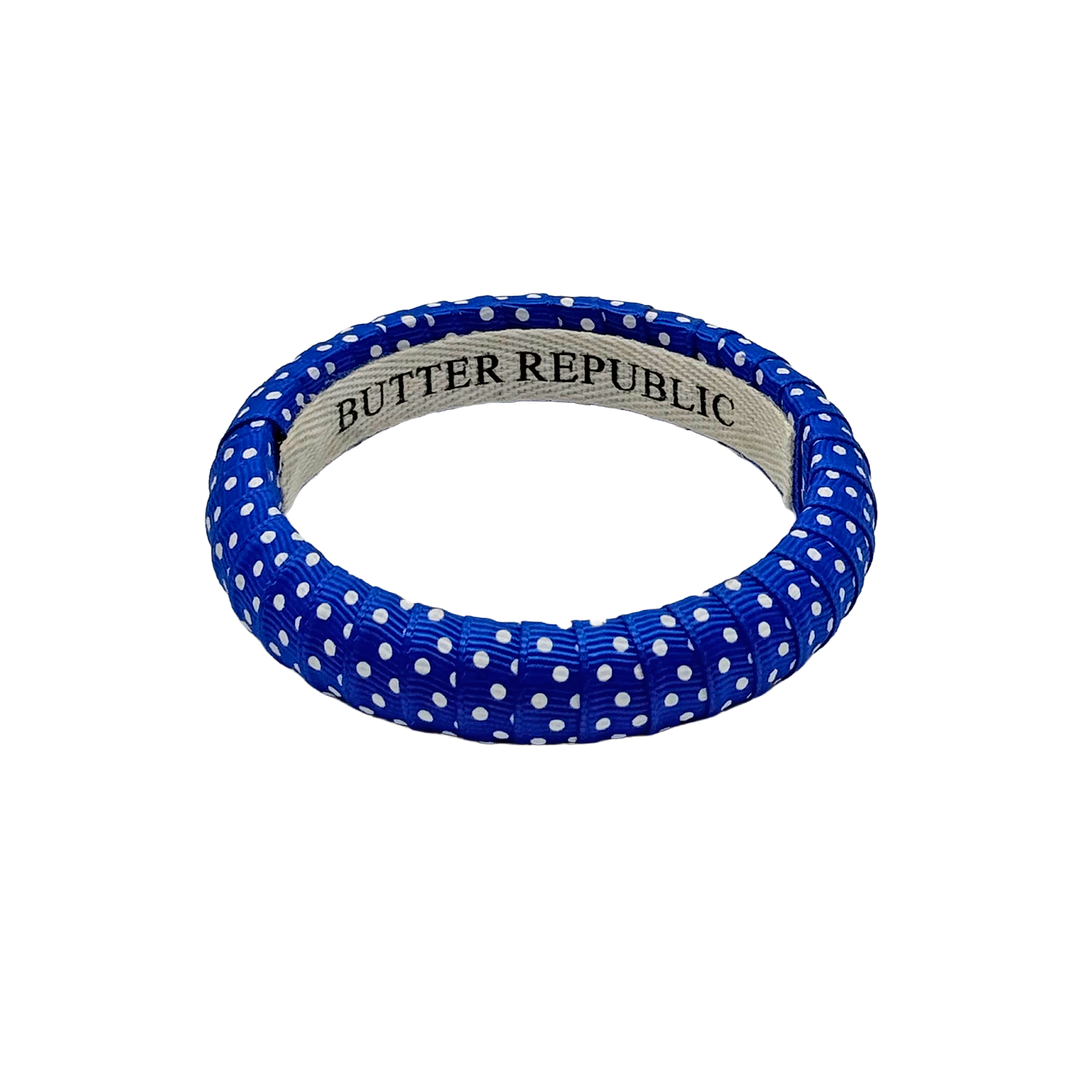 blue and white Swiss dot Butter Republic bracelet with logo brand label on the interior of the bracelet