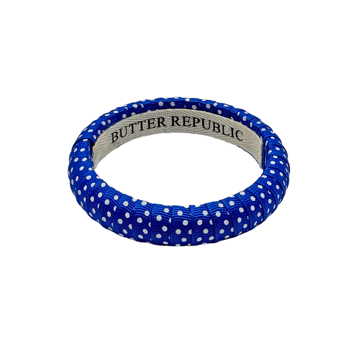 blue and white Swiss dot Butter Republic bracelet with logo brand label on the interior of the bracelet