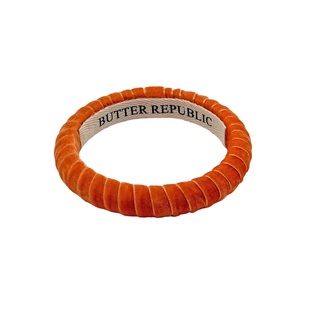 burnt orange velvet Butter Republic bracelet with logo brand label on the interior of the bracelet