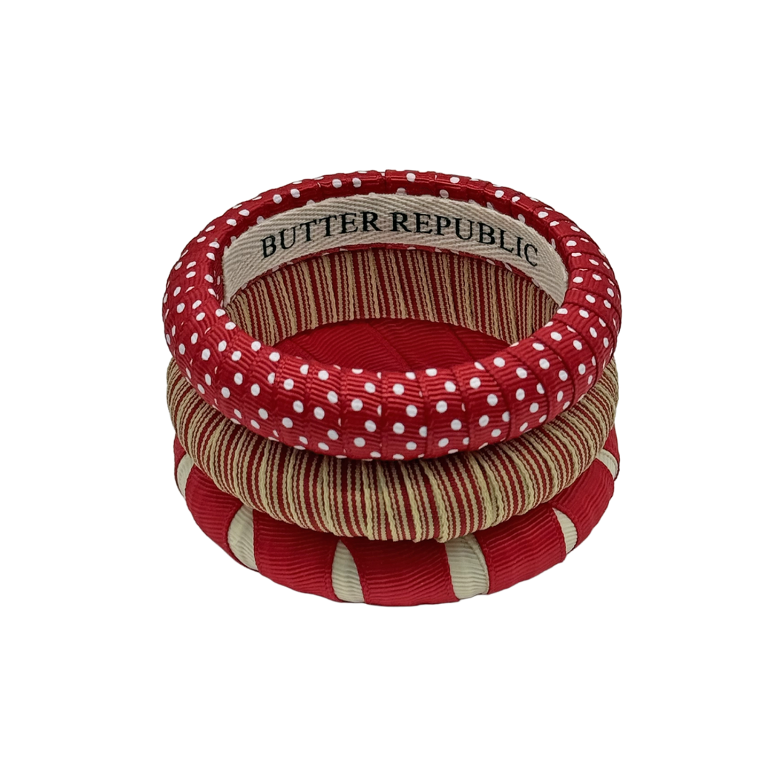 three crimson and cream Butter Republic bracelets stacked with logo brand label on the interior of the bracelet