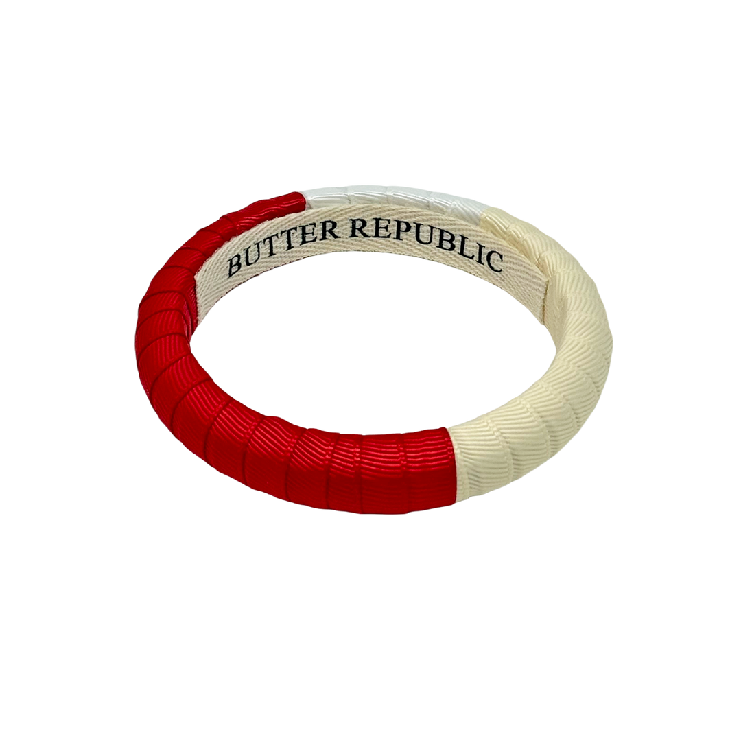 Red, cream, and white color block bracelets with 'Butter Republic' branding on the interior