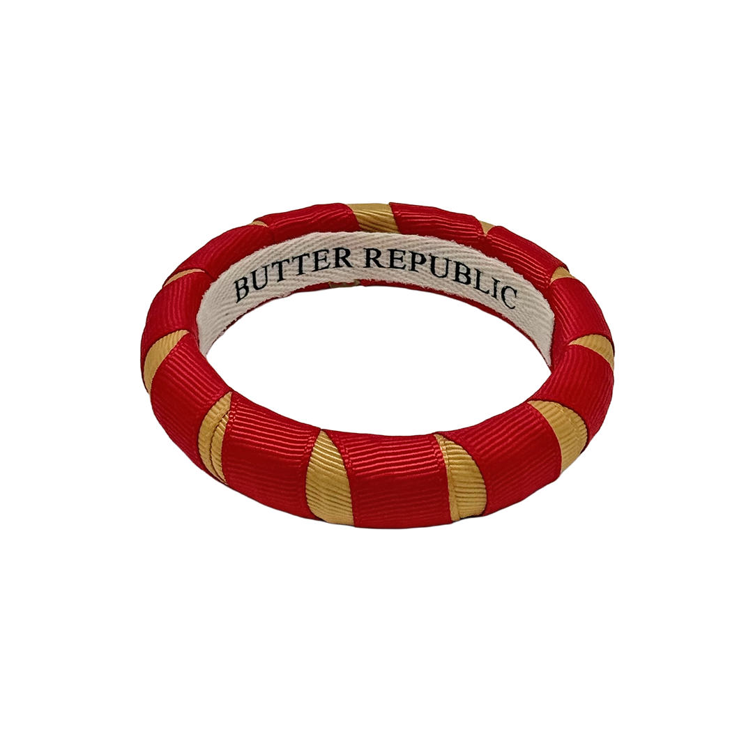 crimson and gold Butter Republic bracelet with logo brand label on the interior of the bracelet