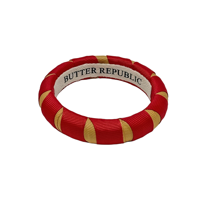 crimson and gold Butter Republic bracelet with logo brand label on the interior of the bracelet