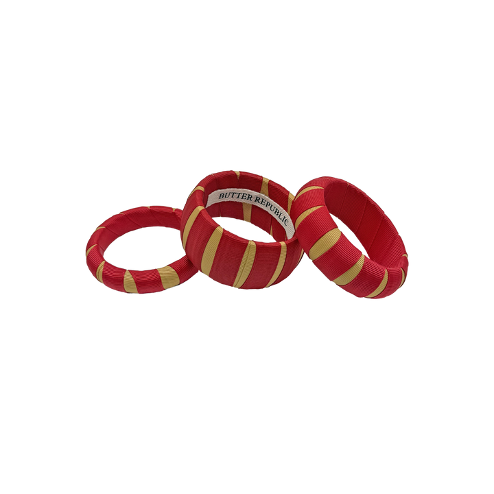 set of three multi-width crimson and gold Butter Republic bracelets with logo brand label on the interior of the bracelet
