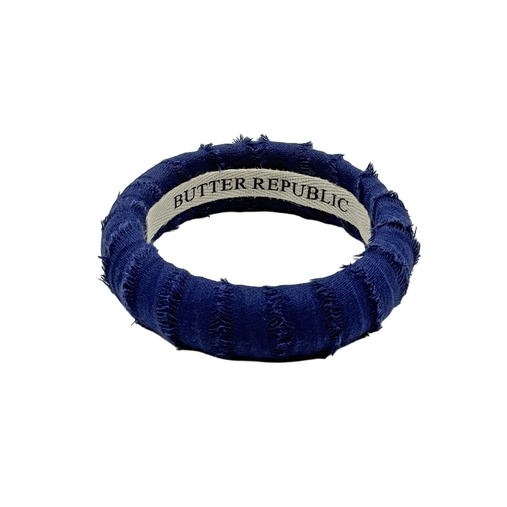 blue frayed Butter Republic bracelet with logo brand label on the interior of the bracelet