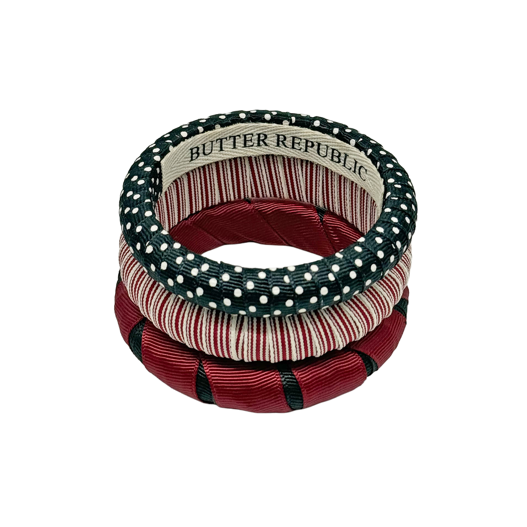Stack of garnet and black Butter Republic bangle bracelets with brand label on the interior