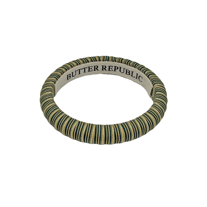 Green and cream striped Butter Republic bangle bracelet with brand label on the interior