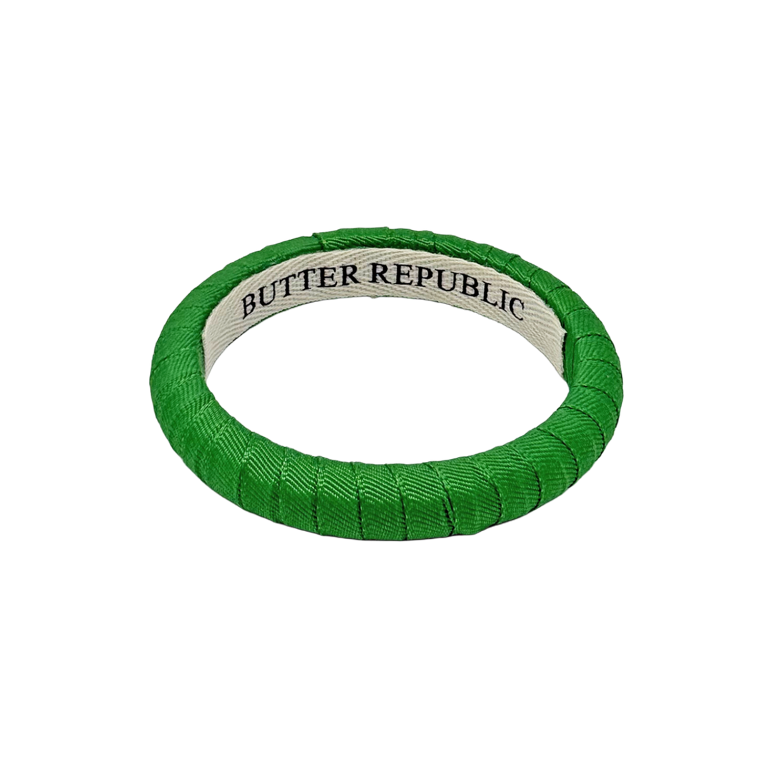 green narrow Butter Republic bracelet with a brand label on the interior of the bracelet