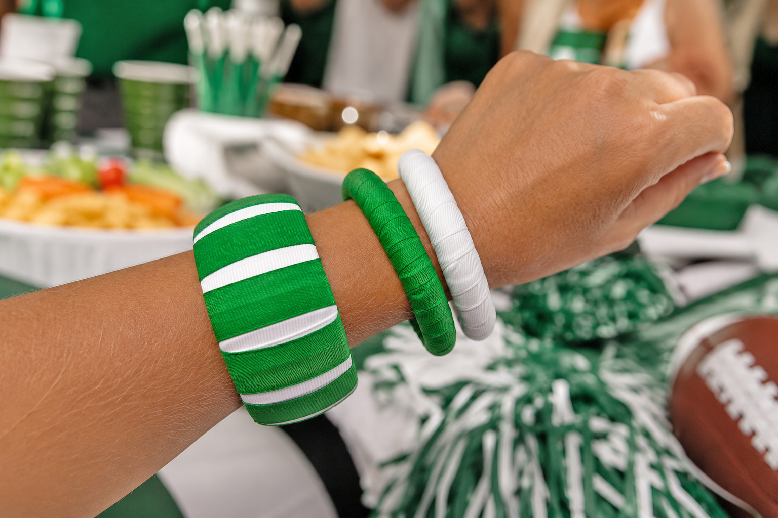 A close-up of a woman's wrist wearing three green and white Butter Republic bangle bracelets