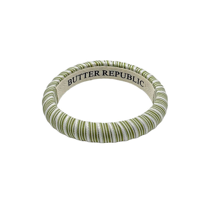green and white striped Butter Republic bracelet with logo brand label on the interior of the bracelet