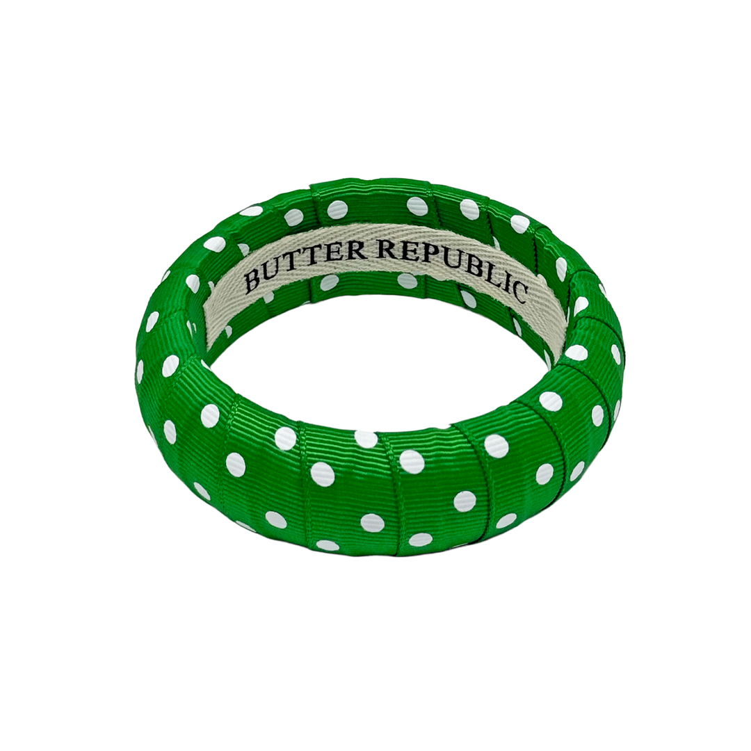 Green and white polka dot bracelet with Butter Republic brand label on the interior