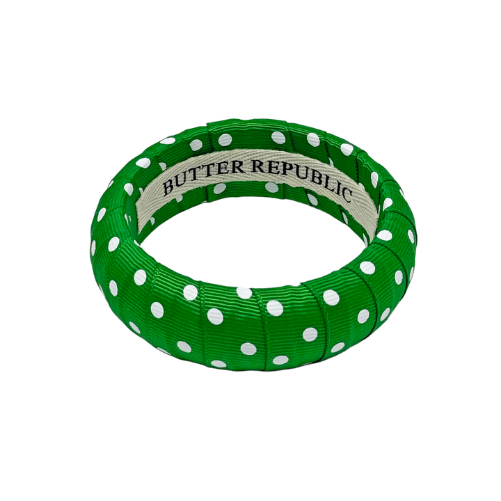 Green and white polka dot bracelet with Butter Republic brand label on the interior