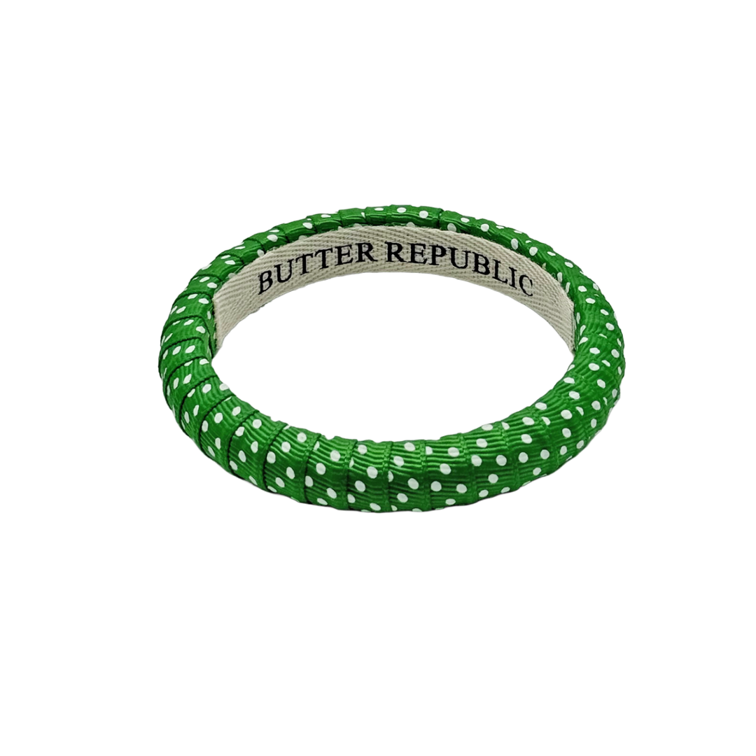 green Butter Republic bracelet with white Swiss dots and logo brand label on the interior of the bracelet