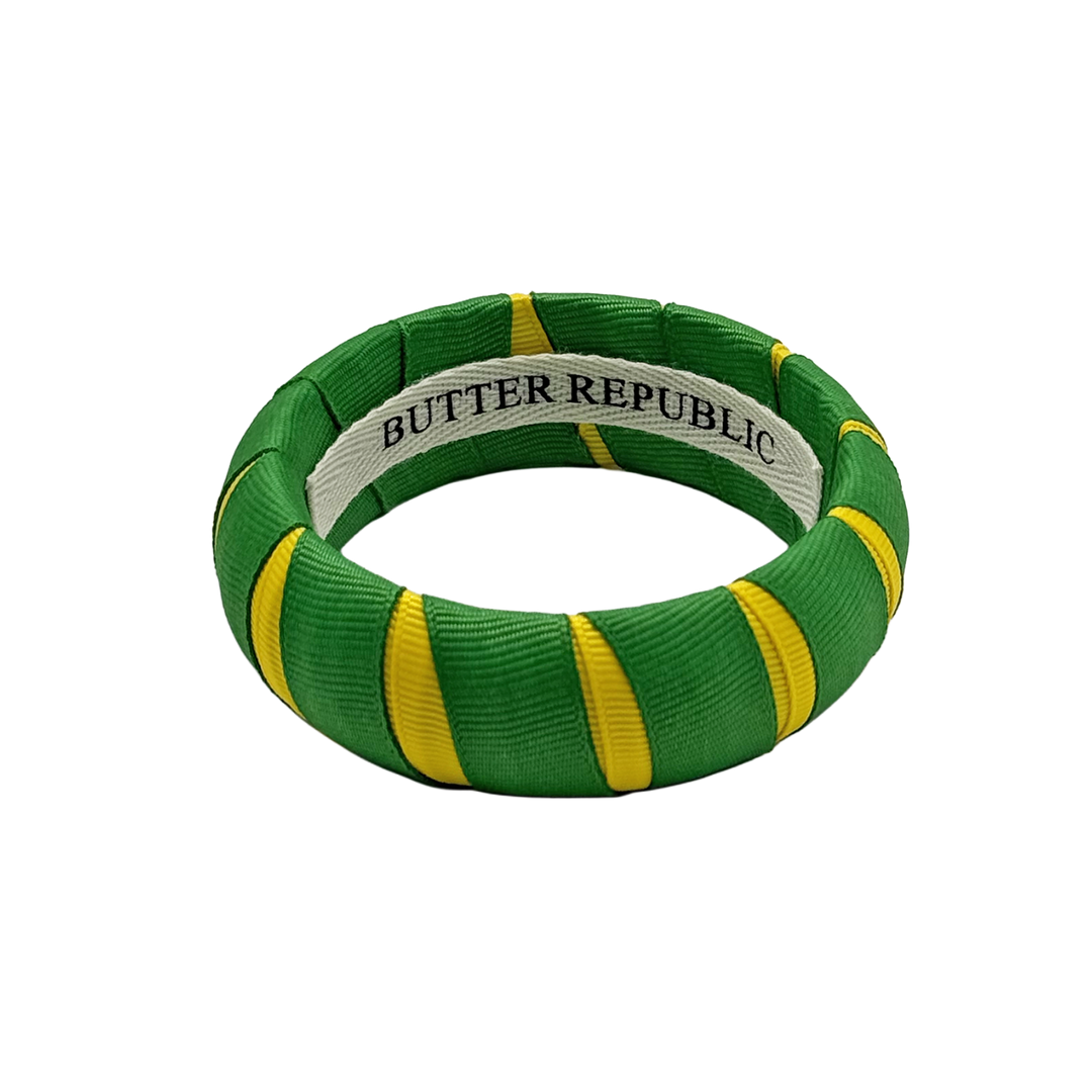 green and yellow Butter Republic bracelet with logo brand label on the interior of the bracelet
