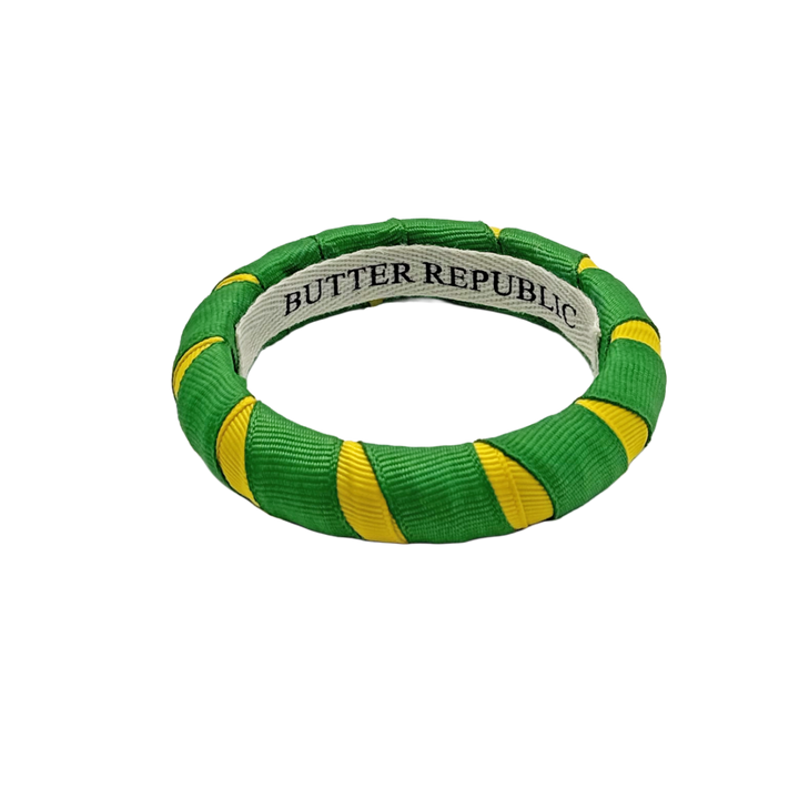green and yellow Butter Republic bracelet with logo brand label on the interior of the bracelet