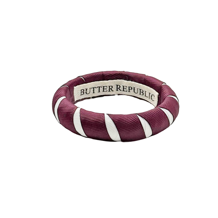 maroon and white Butter Republic bracelet with logo brand label on the interior of the bracelet