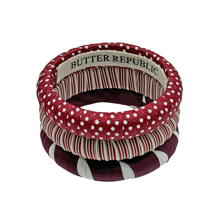 three maroon and white Butter Republic bracelets stacked, with logo brand label on the interior of the bracelet