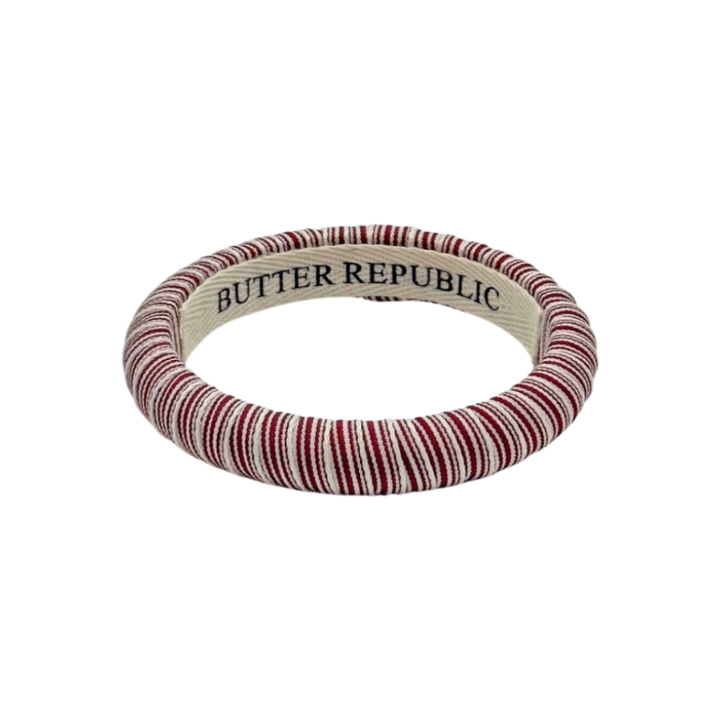 maroon and white striped Butter Republic bracelet with logo brand label on the interior of the bracelet