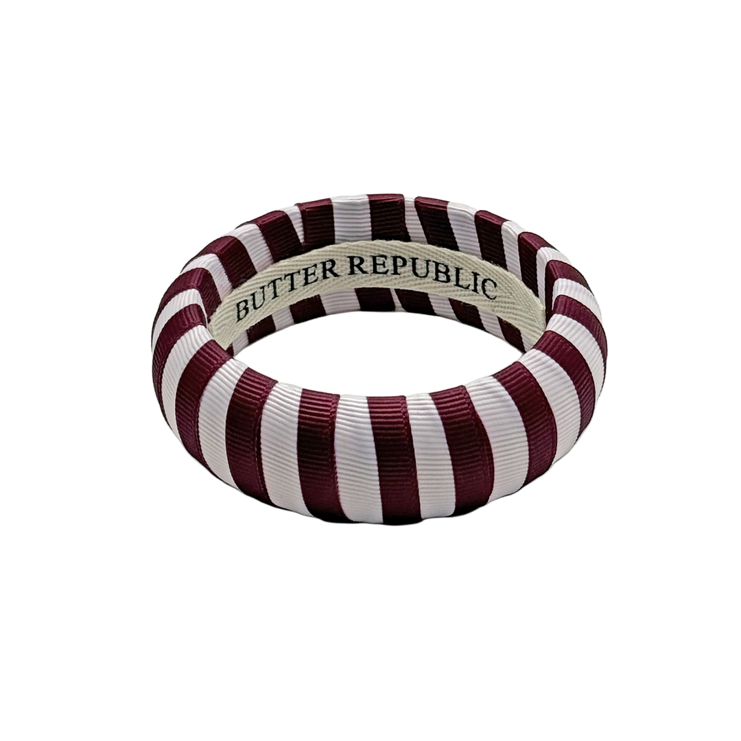 maroon and white striped Butter Republic bracelet with logo brand label on the interior of the bracelet