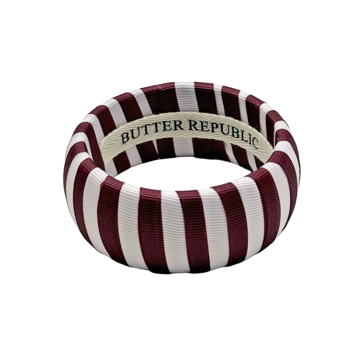 maroon and white striped Butter Republic bracelet with logo brand label on the interior of the bracelet