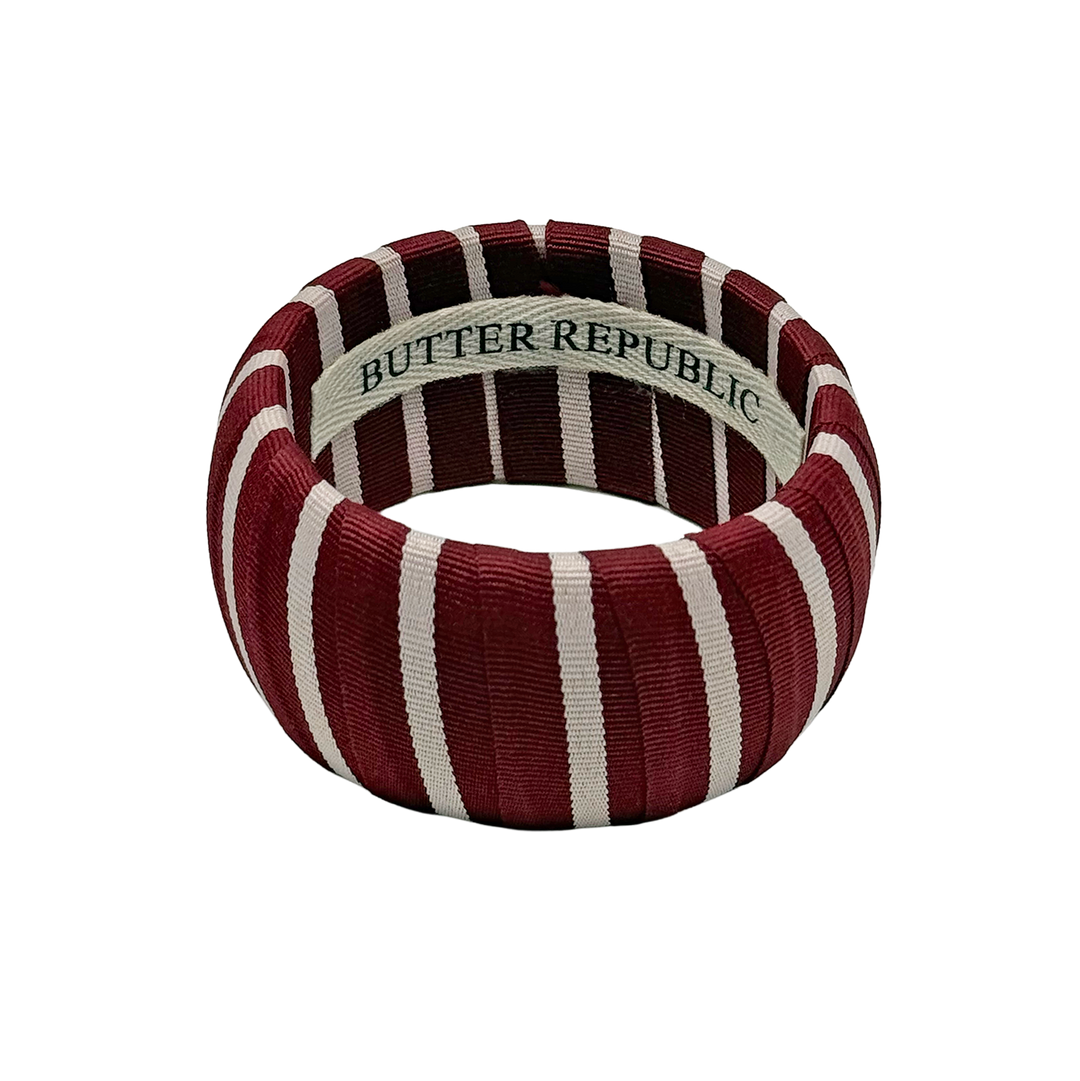 maroon and white striped wide Butter Republic bracelet with a logo brand label on the interior of the bracelet