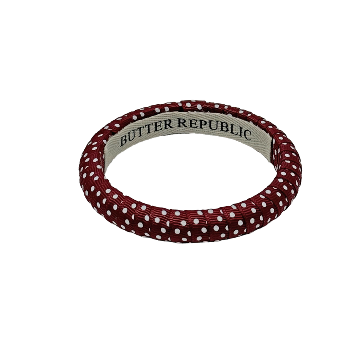 maroon and white Swiss dot Butter Republic bracelet with logo brand label on the interior of the bracelet