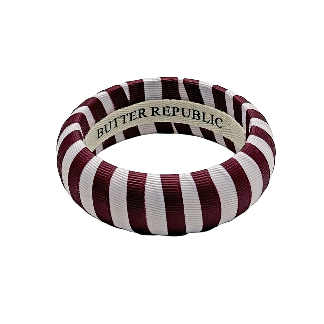 Striped maroon and white bracelet with 'Butter Republic' branding on the interior
