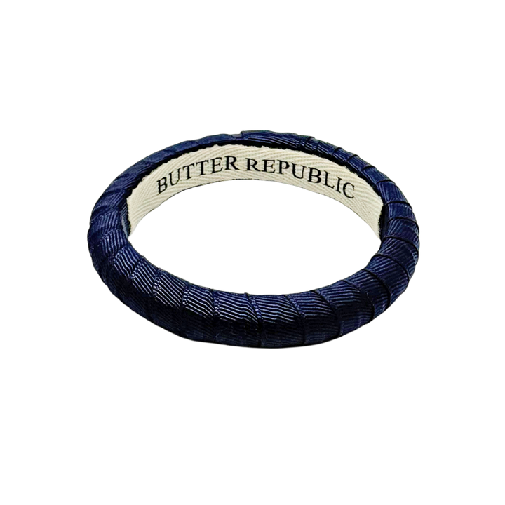 navy blue narrow Butter Republic bracelet with brand label on the interior