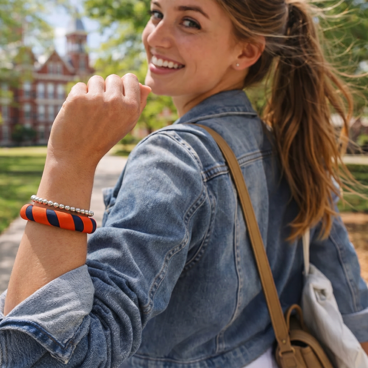 Young woman wearing a navy blue and orange Butter Republic bracelet with a denim jacket outdoors