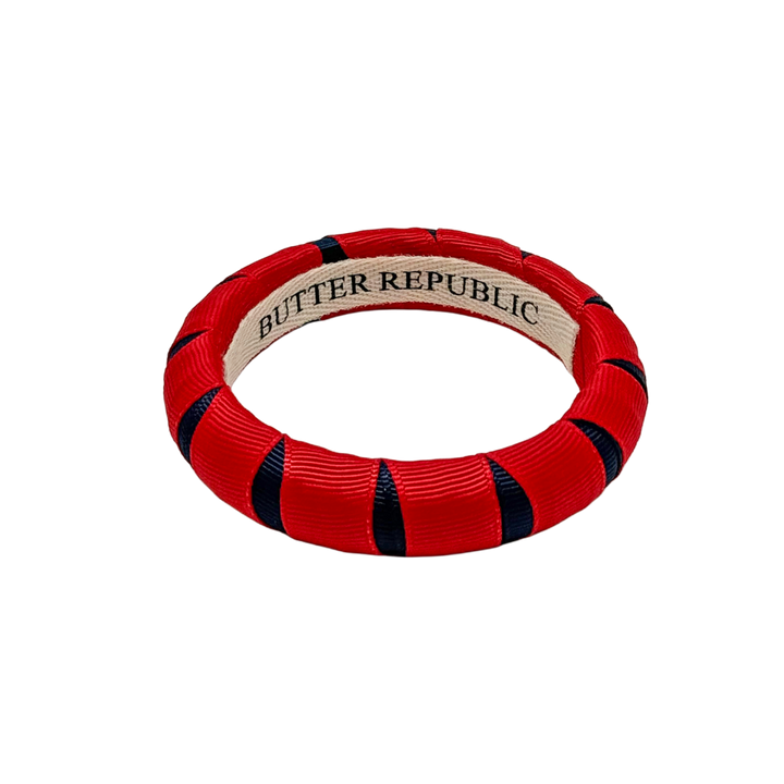 navy blue and red Butter Republic bracelet with logo brand label on the interior of the bracelet
