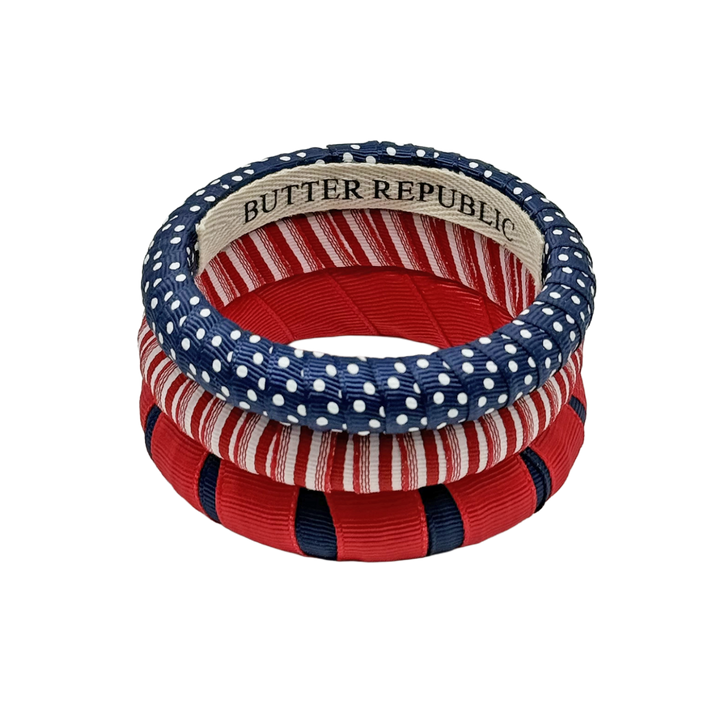 three stacked Butter Republic bracelets in navy blue and red, with logo brand label on the interior of the bracelet